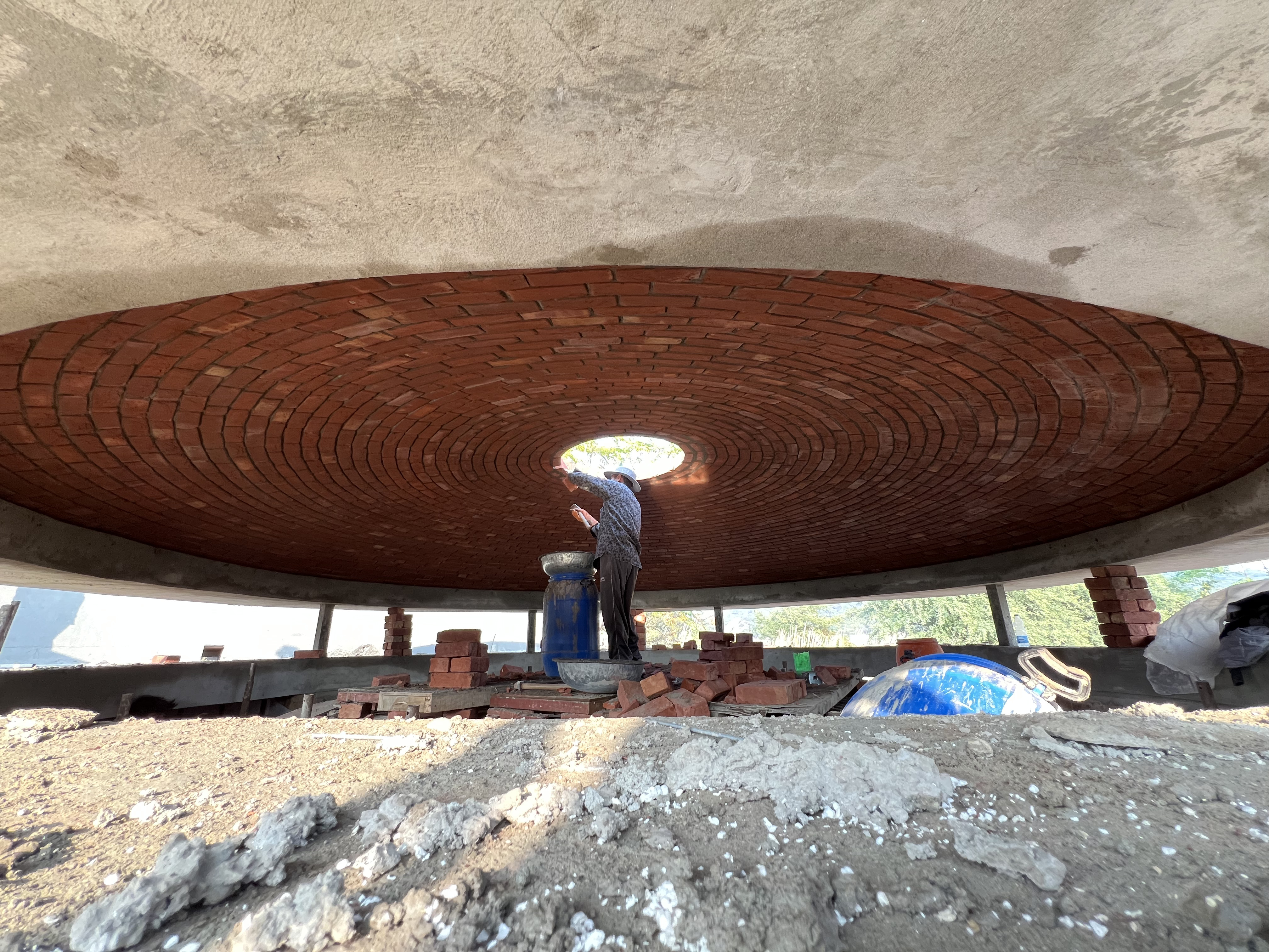 Wide view of worker at center of large circular dome construction - Rohtak Domes 2025