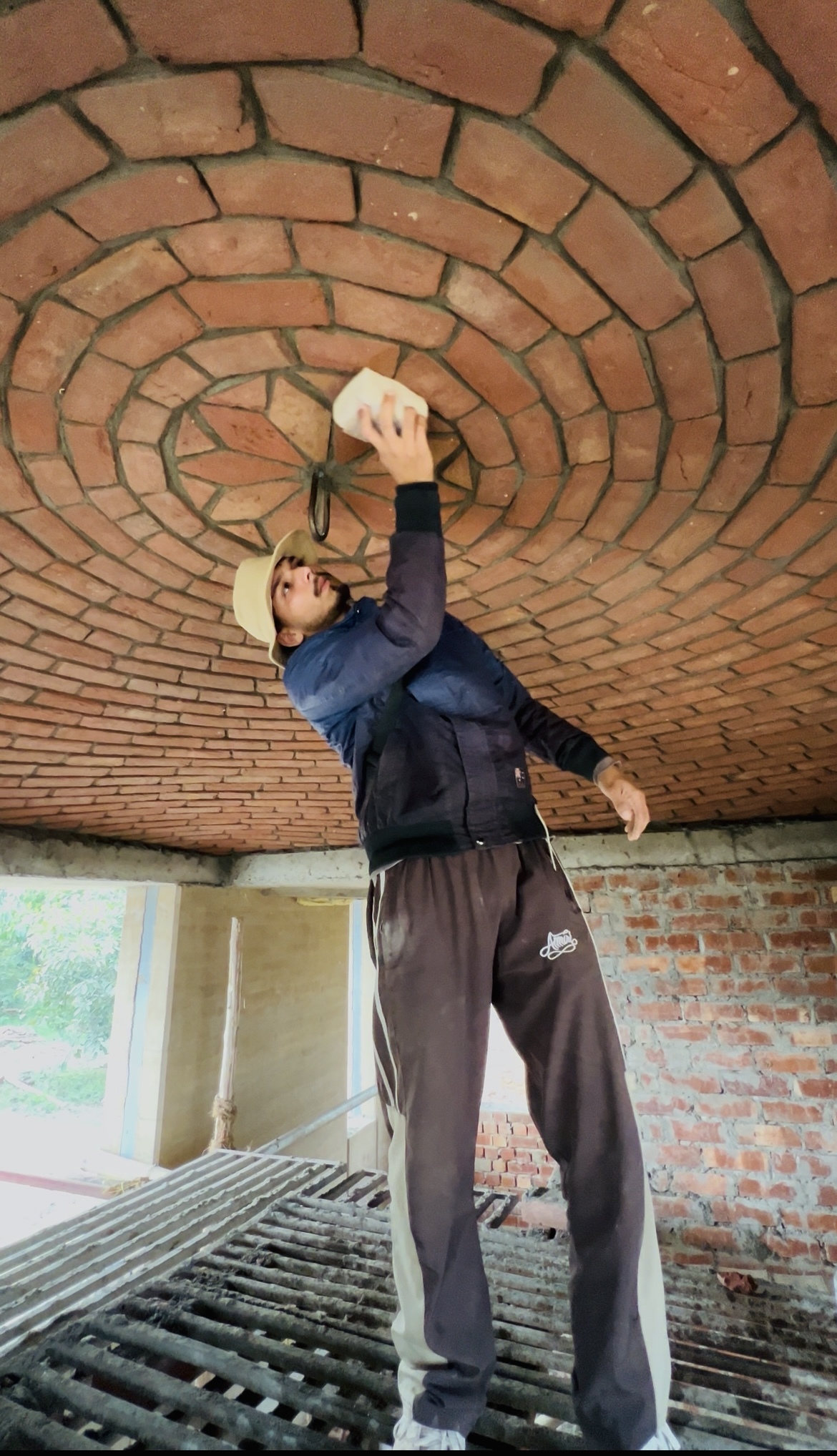 Craftsman constructing circular brick dome ceiling with radial pattern - Rohtak Domes 2024