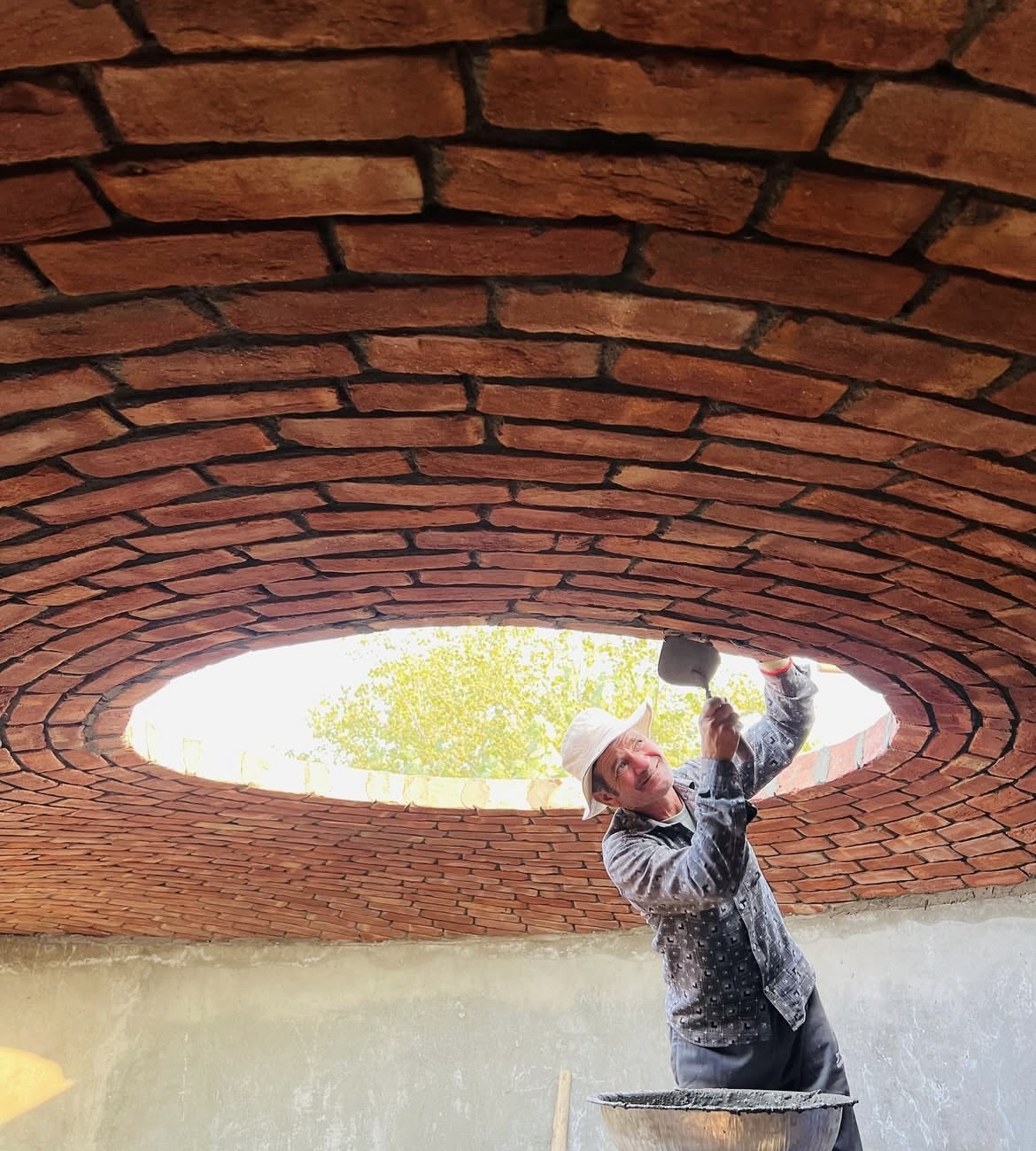 Craftsman working on circular brick dome with central oculus - Rohtak Domes 2024