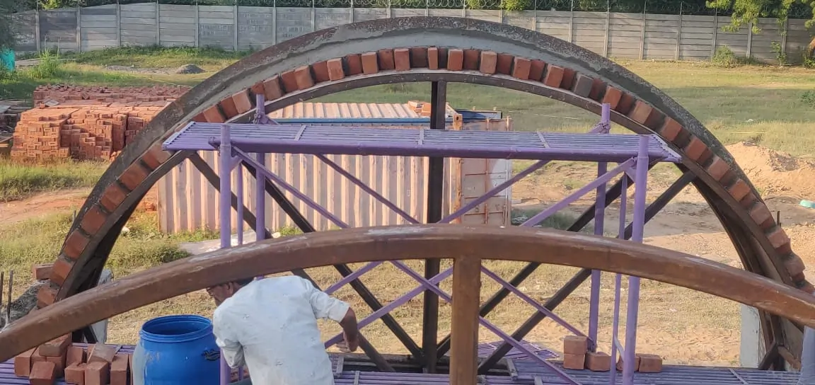 Construction of a brick arch with scaffolding by Rohtak Domes